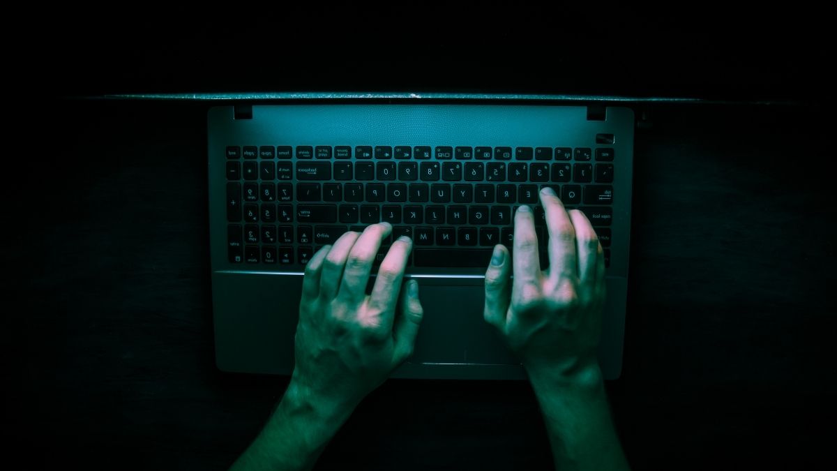 hands using laptop in low lighting
