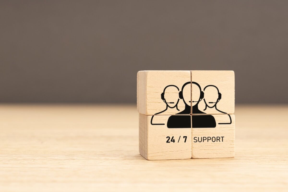 wooden blocks with an illustration of three IT support technicians and the words 24/7 support